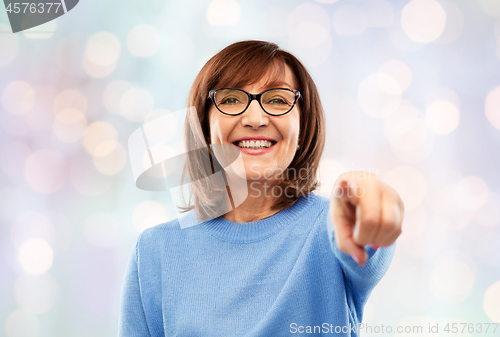 Image of senior woman in glasses pointing finger to you