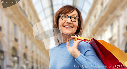 Image of senior woman with shopping bags over mall