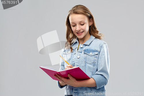 Image of teenage student girl writing to diary or notebook