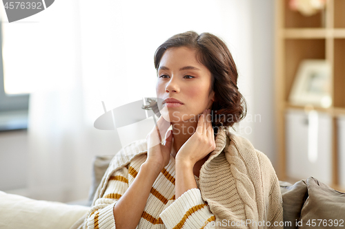 Image of sick woman touching her lymph nodes at home
