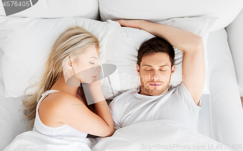 Image of happy couple sleeping in bed at home