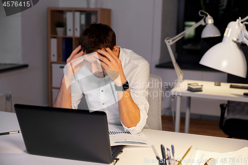 Image of businessman with papers working at night office