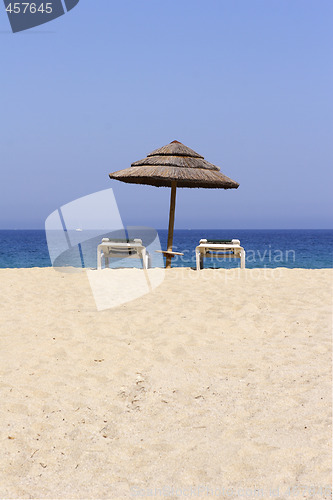 Image of sun lounger on empty sandy beach