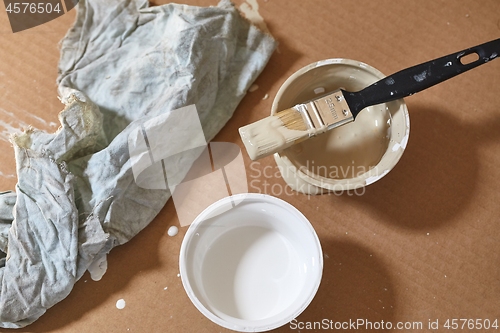 Image of Paint brush on a can of white wall paint