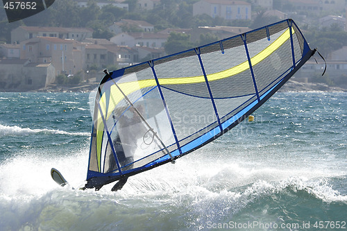 Image of expert windsurfer in strong wind, surfing his board