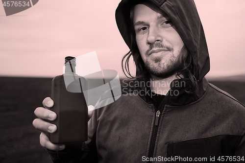 Image of Hooded man drinking spirits in Iceland