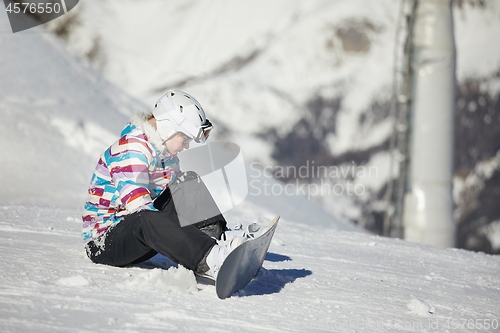 Image of Snowboarder sitting in the snlow