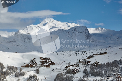 Image of Snowy mountain landscape with skiing resort village and lifts