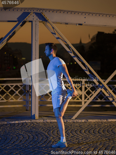 Image of man jogging across the bridge in the city