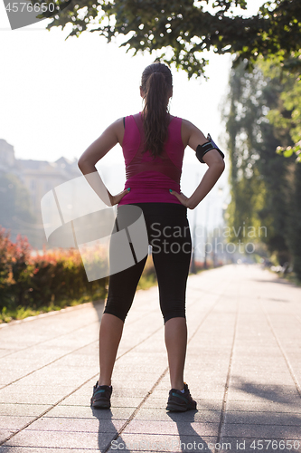 Image of woman jogging at sunny morning