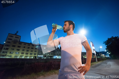 Image of man drinking water after running session