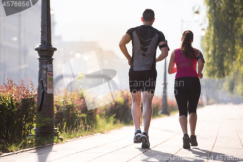 Image of young couple jogging  in the city