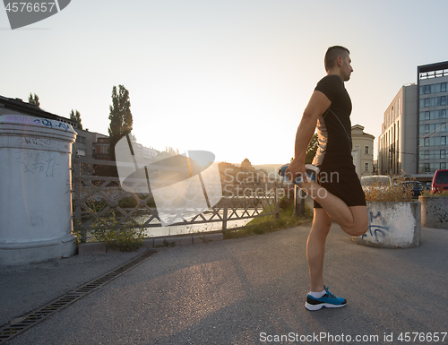 Image of athlete man warming up and stretching