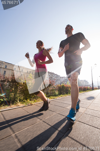 Image of young couple jogging  in the city