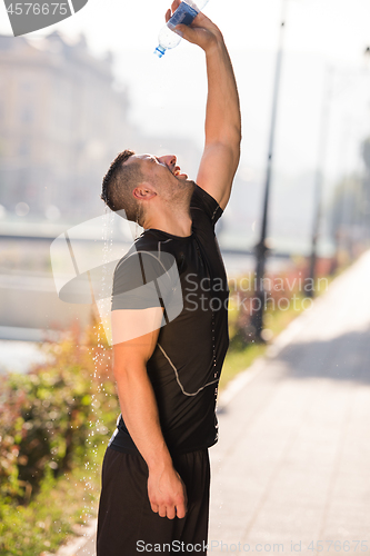 Image of man pouring water from bottle on his head