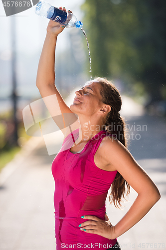 Image of woman pouring water from bottle on her head