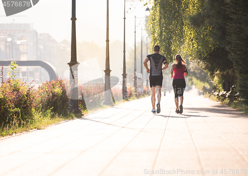 Image of young couple jogging  in the city