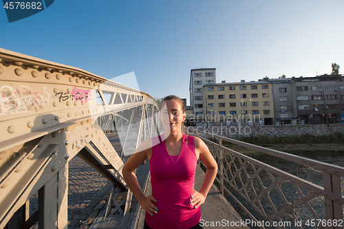 Image of portrait of a jogging woman at sunny morning