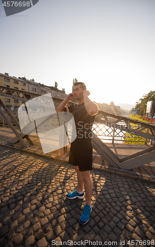 Image of portrait of a jogging man at sunny morning