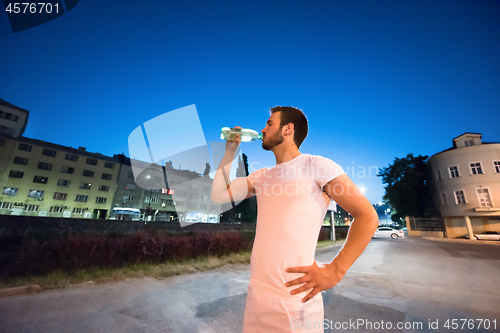 Image of man drinking water after running session