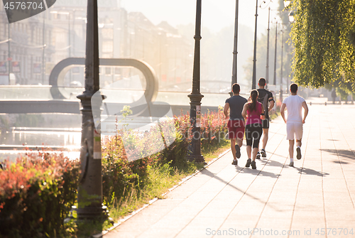 Image of group of young people jogging in the city