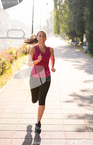 Image of woman jogging at sunny morning