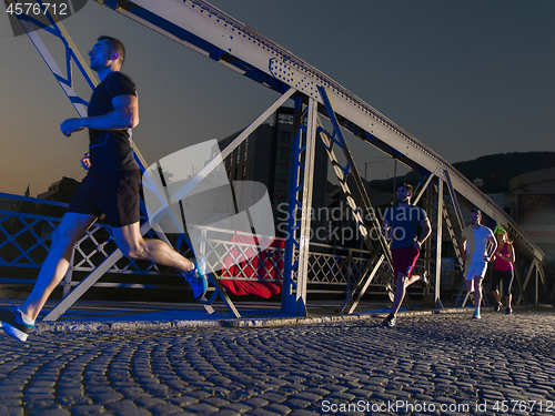 Image of young people jogging across the bridge