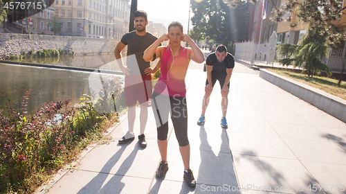 Image of group of young people jogging in the city