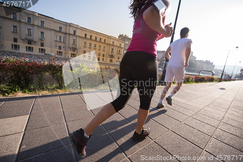 Image of young couple jogging  in the city