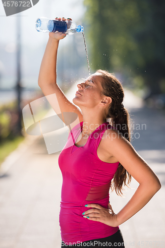 Image of woman pouring water from bottle on her head