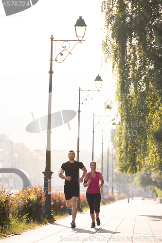 Image of young couple jogging  in the city