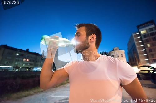 Image of man drinking water after running session