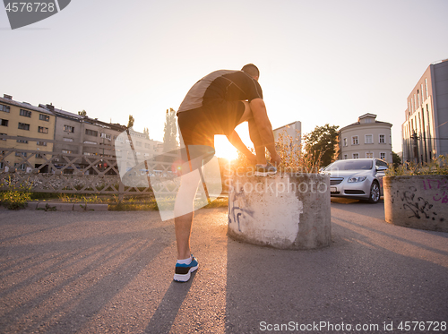 Image of man tying running shoes laces