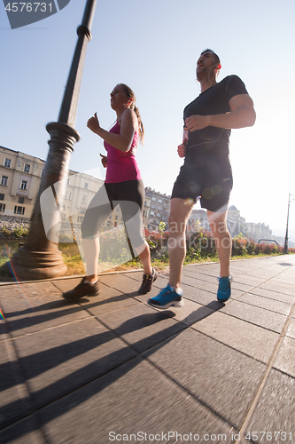 Image of young couple jogging  in the city