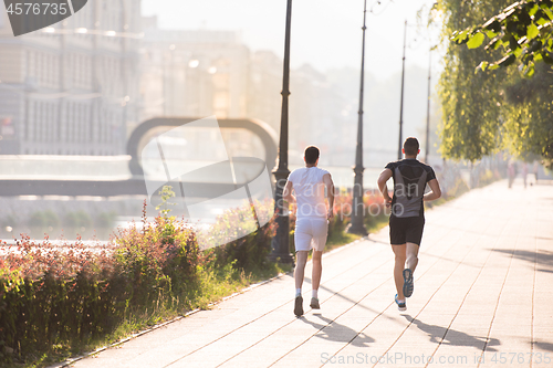 Image of group of young people jogging in the city