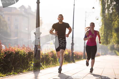 Image of young couple jogging  in the city