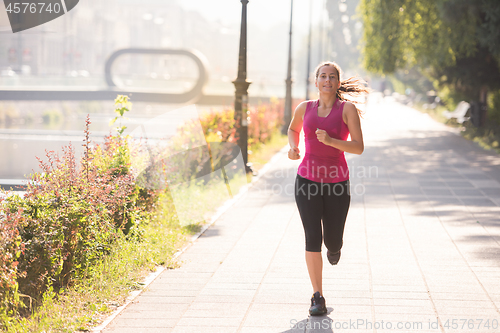 Image of woman jogging at sunny morning