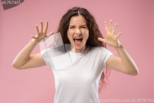 Image of Portrait of an angry woman isolated on a pink background