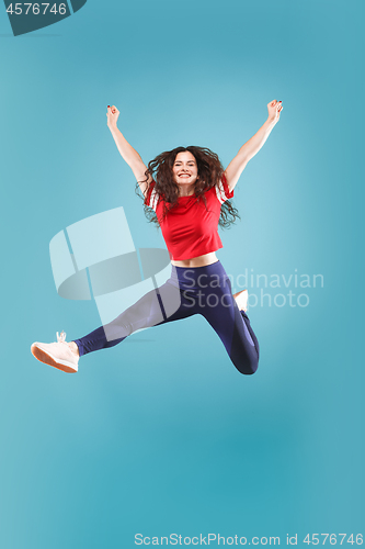 Image of Freedom in moving. Pretty young woman jumping against pink background