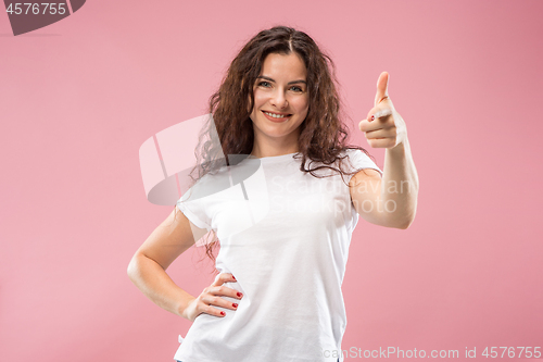 Image of The happy business woman standing and smiling against pink background.