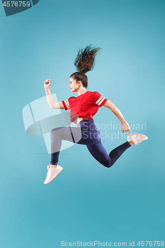 Image of Freedom in moving. Pretty young woman jumping against pink background