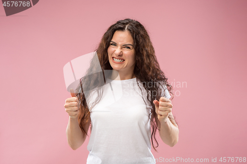 Image of Portrait of an angry woman isolated on a pink background