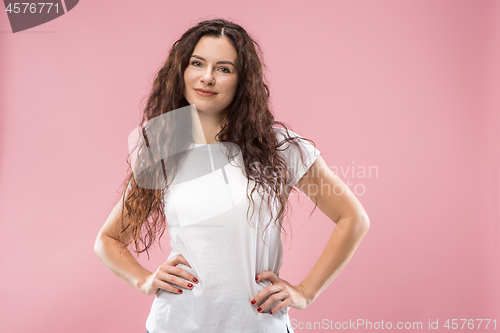 Image of The happy business woman standing and smiling against pink background.