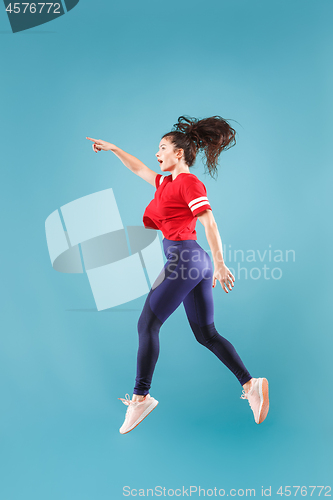 Image of Freedom in moving. Pretty young woman jumping against pink background