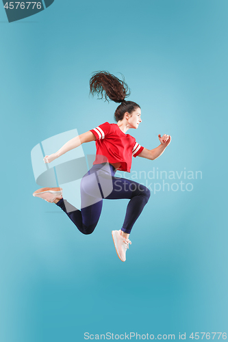 Image of Freedom in moving. Pretty young woman jumping against pink background