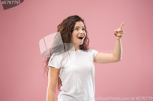Image of Beautiful woman looking suprised isolated on pink