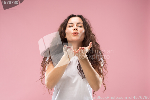 Image of The happy business woman standing and smiling against pink background.