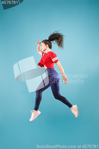 Image of Freedom in moving. Pretty young woman jumping against pink background