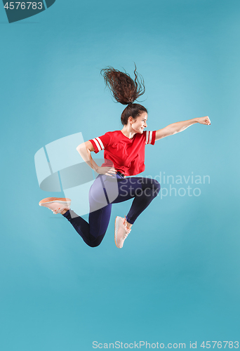 Image of Freedom in moving. Pretty young woman jumping against pink background