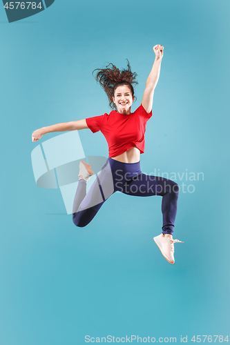 Image of Freedom in moving. Pretty young woman jumping against pink background